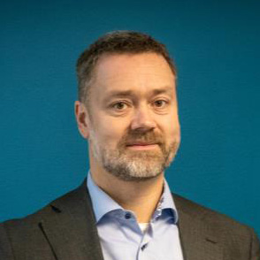 Portrait of a smiling man in a suit against a dark blue background