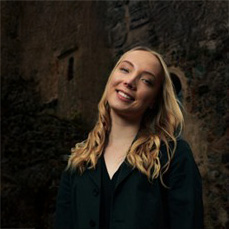 Person i svart blus mot mörk bakgrund