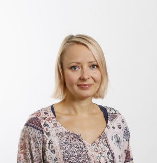 Woman with blond hair against light background.